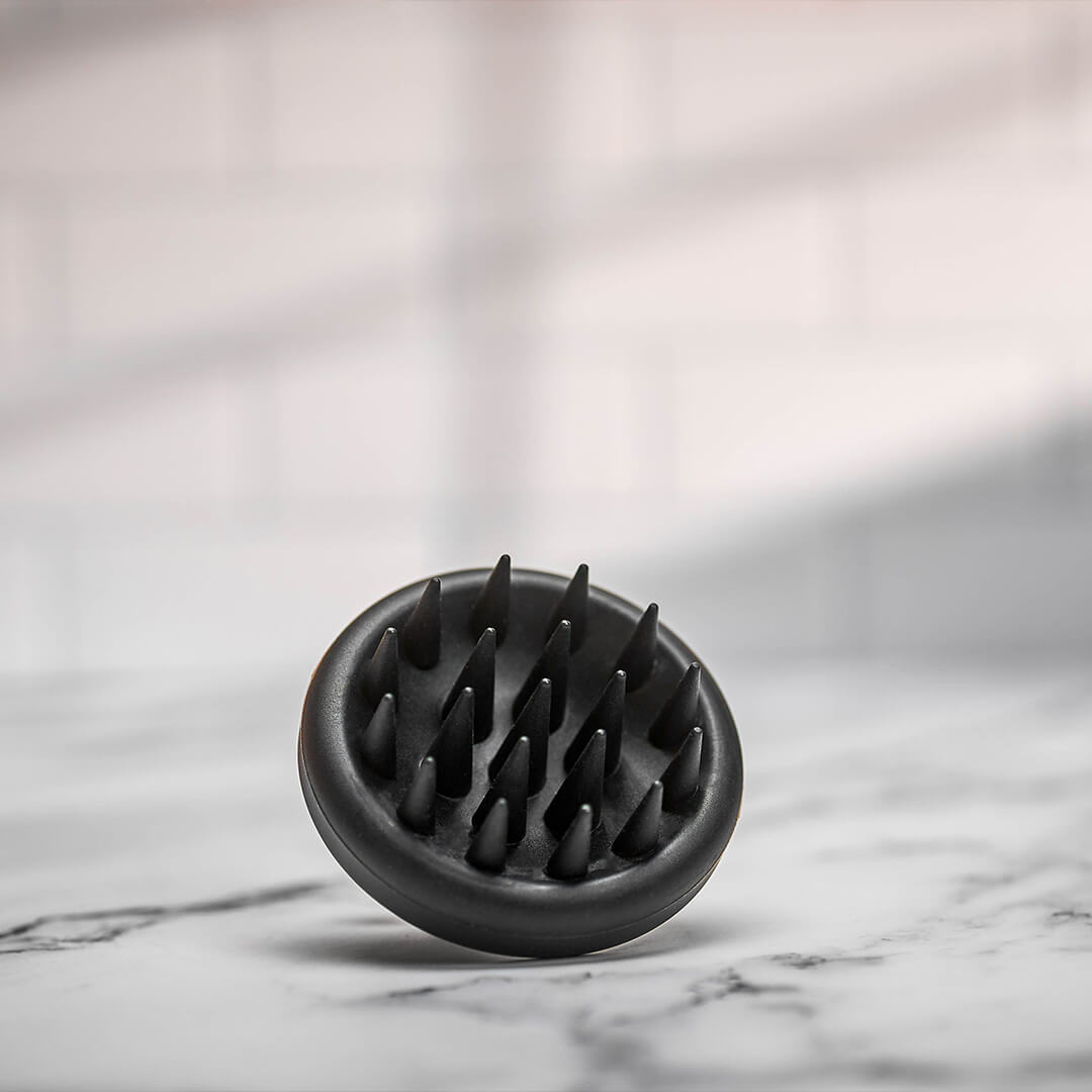 Scalp massager elegantly displayed in a styled photoshoot, highlighting its modern aesthetics.
